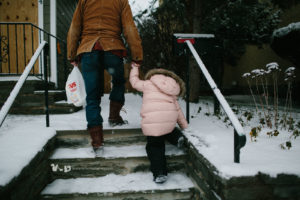 Little girl climbing snowy steps