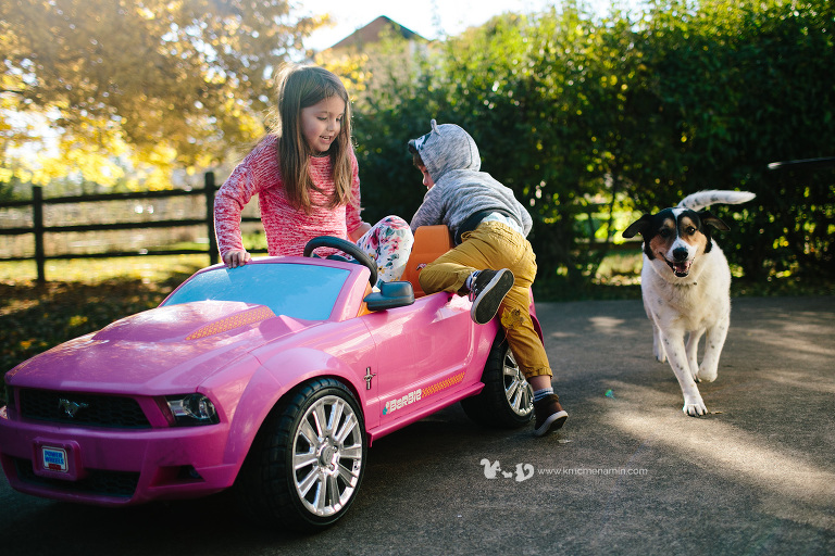 kids getting in play car with dog
