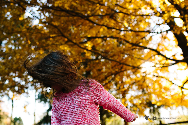 little girl shaking hair in the fall