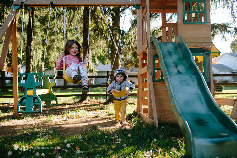 little boy and girl on swing set
