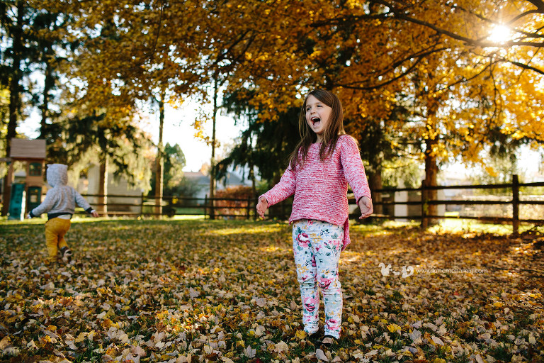little girl excited in fall leaves