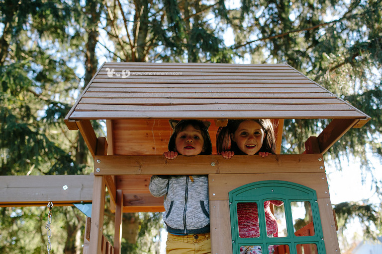 little kids peeking out of playhouse