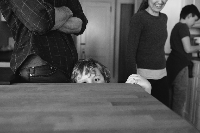 boy peeking over counter in home session