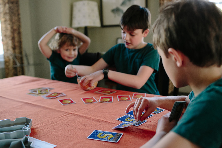boys playing card game in home documentary session