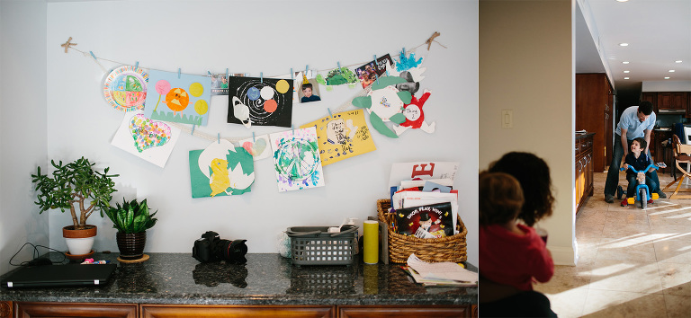 art work hung on walls and little boy on bike in home