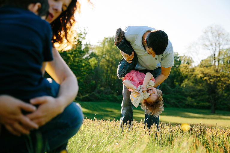boy being held upside down in field