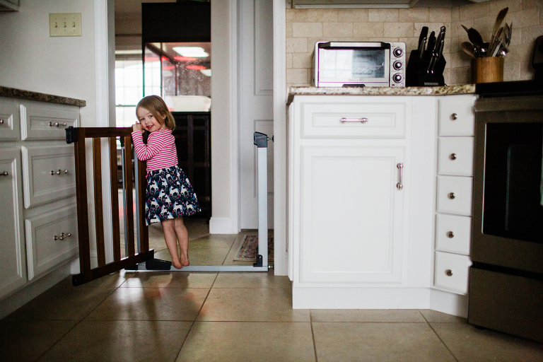 little girl standing in a kitchen