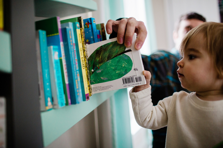 documentary detail photo of girl selecting a book from a bookshelf