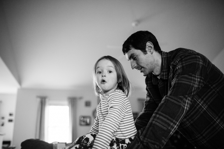 in home photograph of preschool age girl looking at camera and making silly face