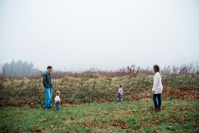 family walking near a hill in the fog