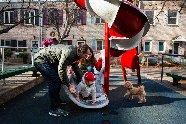 Image of a whole family going down the slide in Coxe Park in Philadelphia