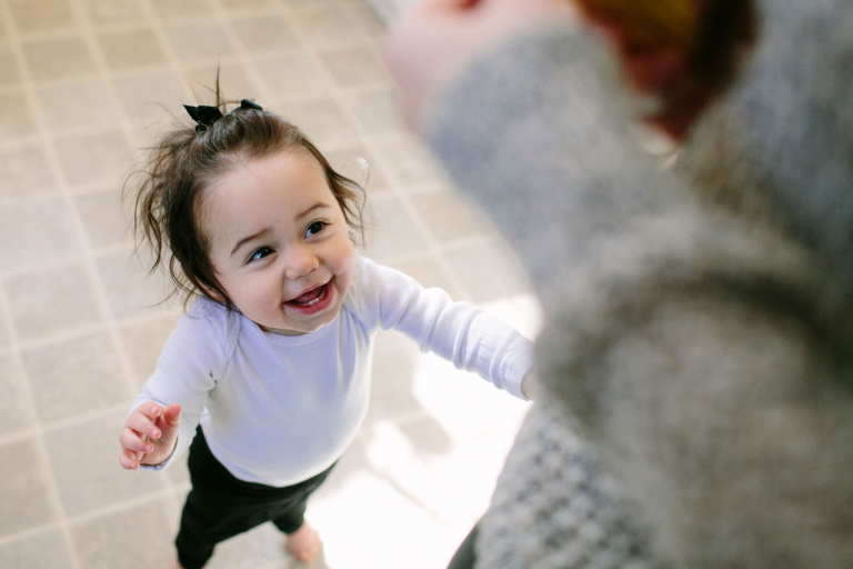 toddler girl looking up at mom