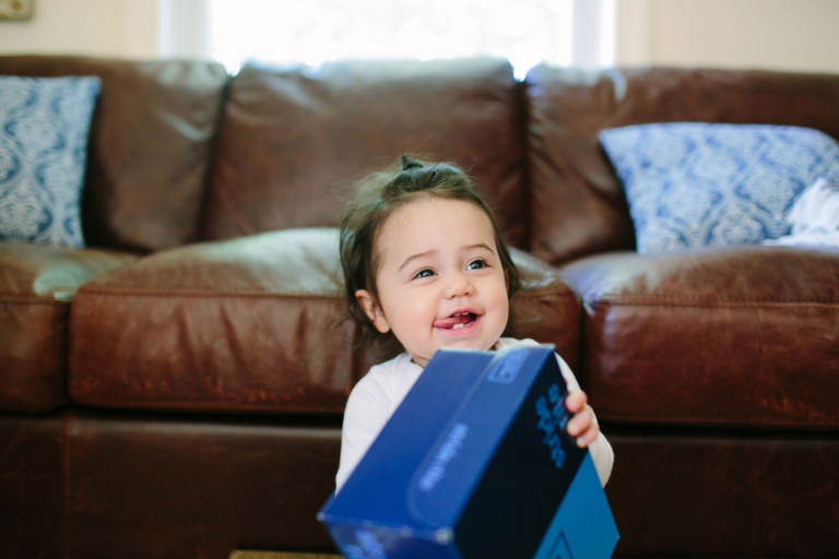 Documentary image of toddler girl smiling and sticking tongue out