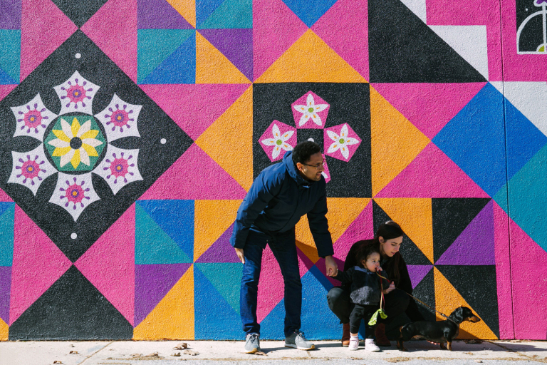 Photograph of family standing in front of a brightly colored wall in Wynnewood