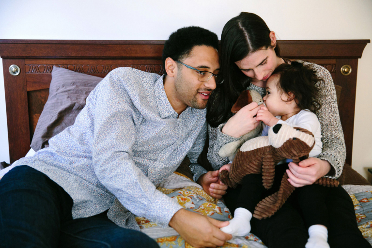 Wynnewood documentary photo of little girl on bed with mom and dad and stuffed dogs