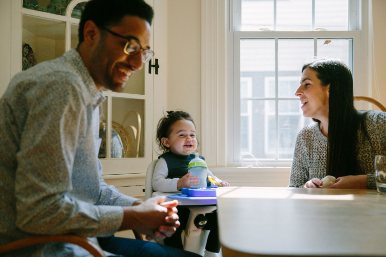 Documentary image of family laughing at dining table