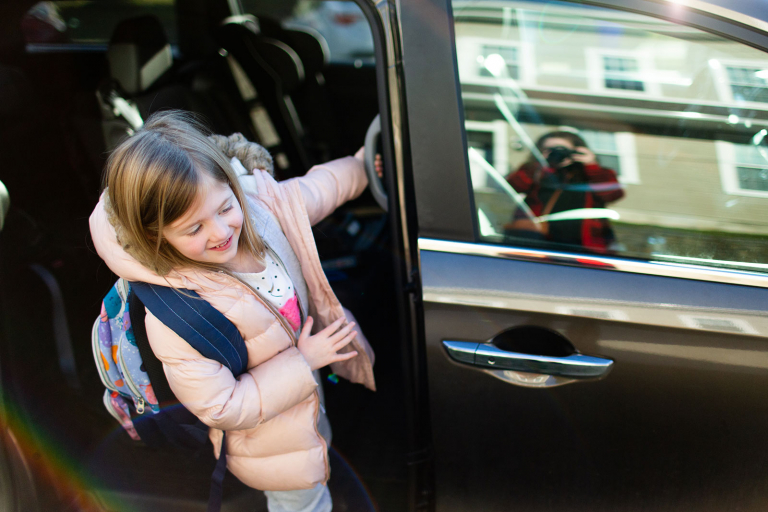 Conshohocken photo of girl getting out of minivan with mom taking picture in reflection