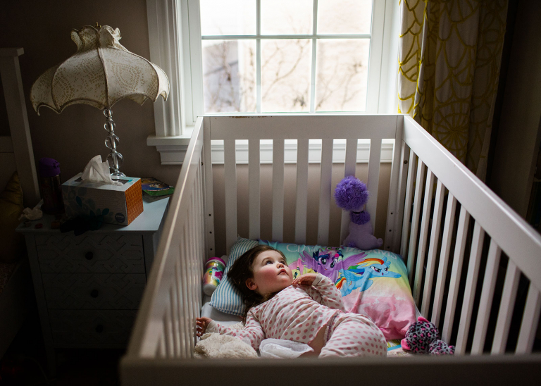 Image of toddler girl in crib having just woken up.