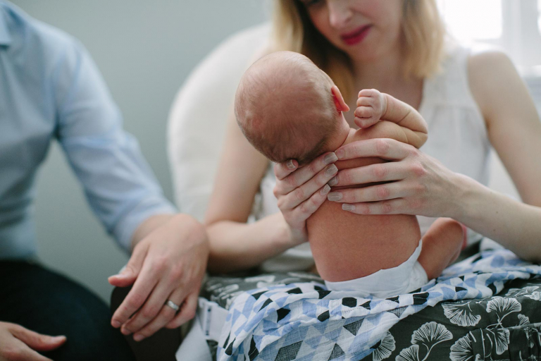 Closeup Image of newborn's back in mom's hands.