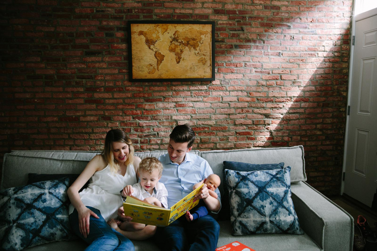 Philadelphia documentary newborn photographer image of family reading together on a couch