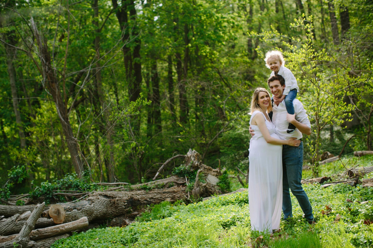 Maternity Photograph of mom, dad and little boy with wooded background