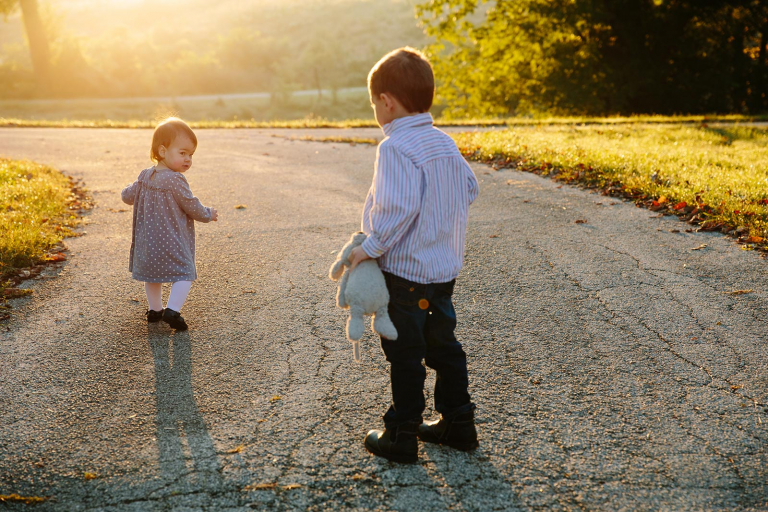 Photograph of brother and sister walking on path at valley forge park at sunrise