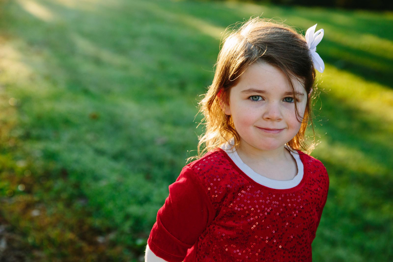 Portrait of little girl in red dress smiling at camera at valley forge