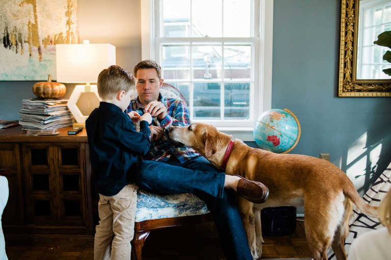photo of dad helping little boy with dog