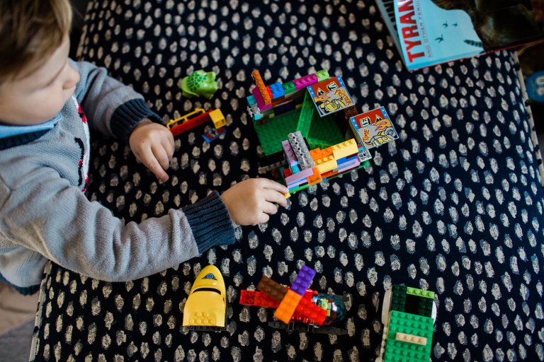 overhead photograph of little boy playing with legos