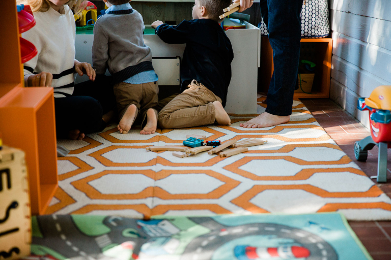 photograph of family feet playing at train table