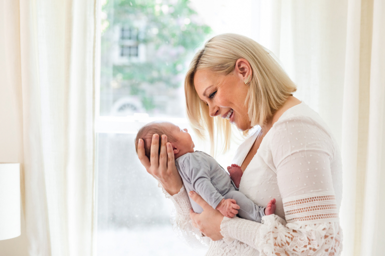 mother smiling warmly down at newborn