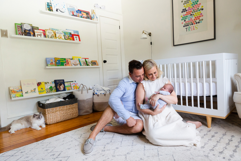 Classic in home Newborn Session family of three cuddling on the floor of classic nursery
